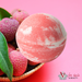 Tilley - Pink Lychee Luxurious Bath Bomb in front of pink lychees
